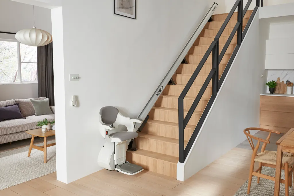 A home lift installed in a modern living room next to a staircase.